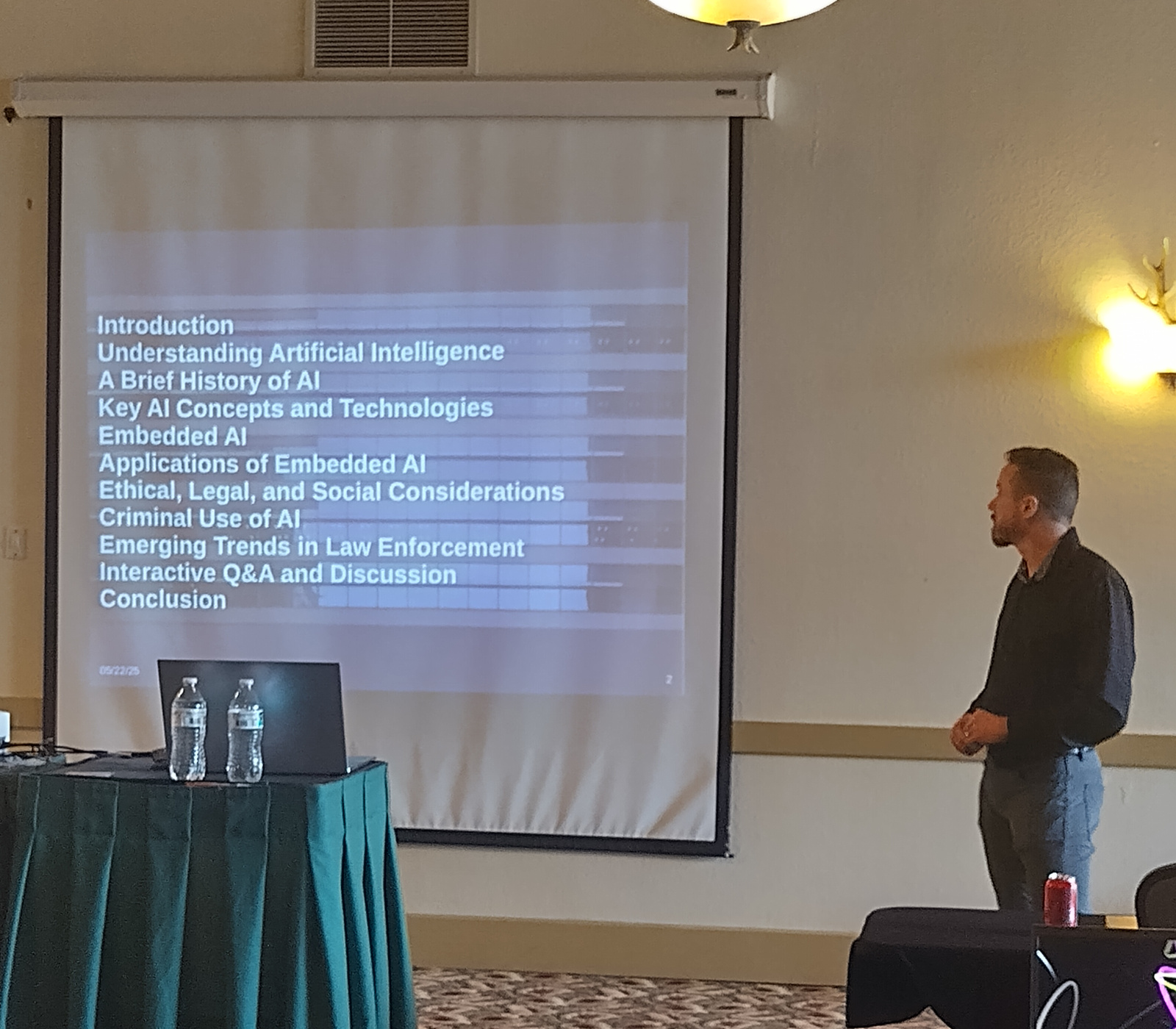 Chris Cole presenting to the High Technology Crime Investigation Association, with the talk's agenda on the screen beside him